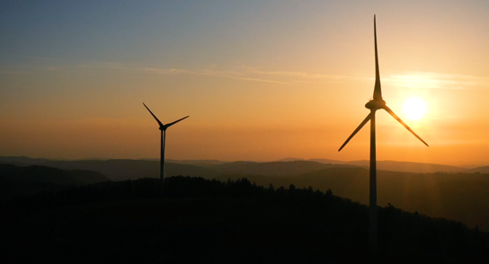 Vidéo NEI Jura où l'on voit des éoliennes sur un couché de soleil.